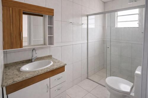 a white bathroom with a sink and a toilet at Pousada Lagus Pan in Capitólio