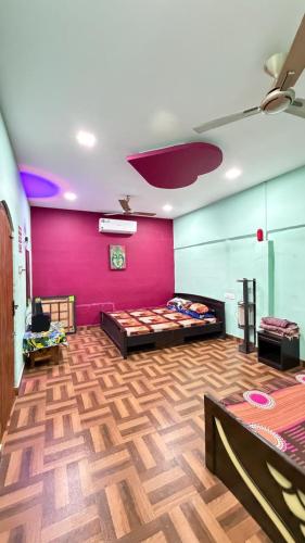 a room with pink walls and a wooden floor at Gravity Groups Core - La Maison Villa in Pondicherry