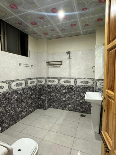 a bathroom with a toilet and a sink at Bhurban Family Apartments in Murree