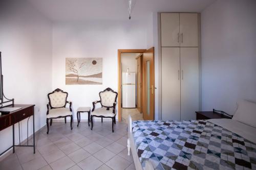 a bedroom with a bed and two chairs and a table at Hara's Studio in Perdika