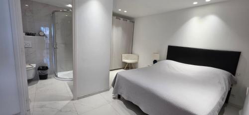 a bedroom with a white bed and a shower at Villa HARMONY in Vallauris