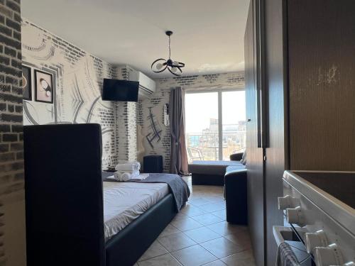 a bedroom with a bed and a couch and a window at Downtown Hub 1 in Alexandroupoli