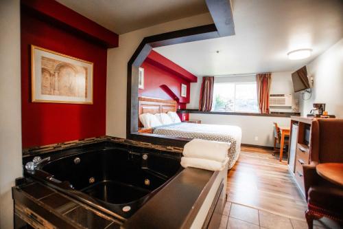 a hotel room with a tub and a bed at Bay City Inn in Bellingham