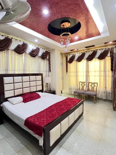a bedroom with a large bed with a red comforter at Bhurban Family Apartments in Murree