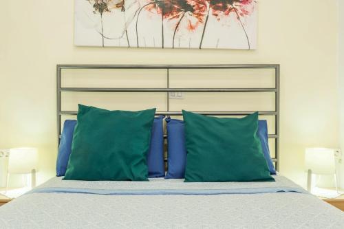 a bedroom with a bed with blue pillows at Sweet Home in Puerto Rico de Gran Canaria