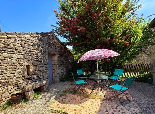a patio with a table and chairs and an umbrella at Chambre d'hôtes Les Bleuets in Melle