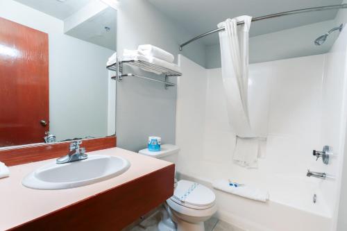 a white bathroom with a sink and a toilet at Bay City Inn in Bellingham