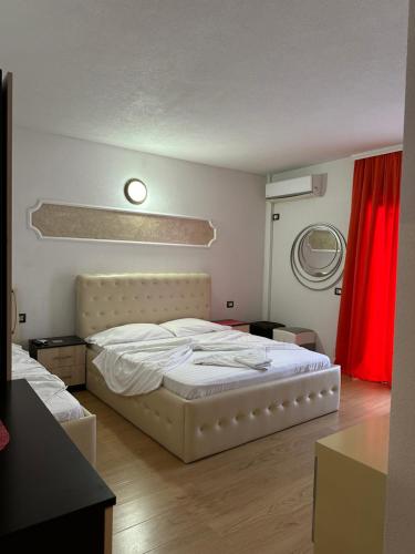a bedroom with a white bed and a red curtain at Hotel Restaurant Real in Kolgecaj