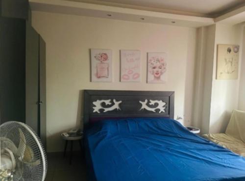 a bedroom with a blue bed with drawings on the wall at chalet in saint remon in Al ‘Ayn