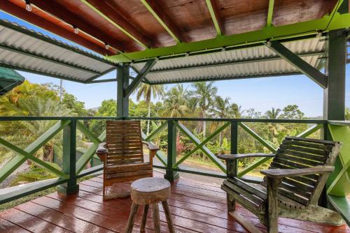 two chairs on a deck with a view of the jungle at The Ceiba Villa by Otium in Aguas Claras