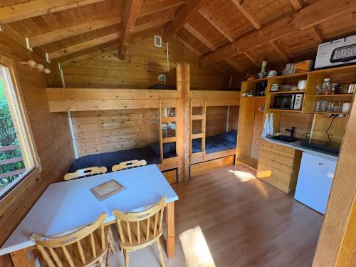 a dining room with a table and chairs in a cabin at Chalet Le CERF in Marigny