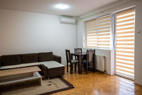 a living room with a couch and a table and chairs at Apartman in Trebinje