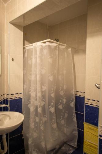 a shower with a white shower curtain in a bathroom at Apartman in Trebinje