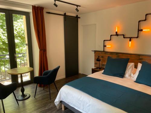 a bedroom with a bed and a table and a window at Atelier St Jean - Chambres d'hôtes in Montluçon