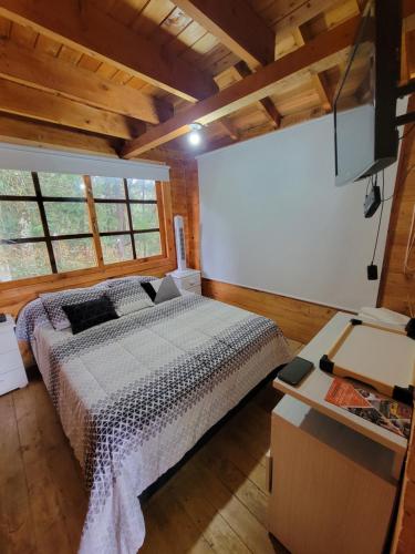 a bedroom with a bed in a room with wooden ceilings at Cozy Cabin in avocado farm in Marinilla