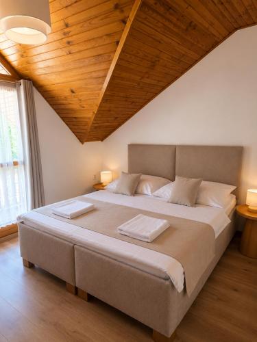 a bedroom with a large bed with a wooden ceiling at Penzion Centrum in Sklené Teplice