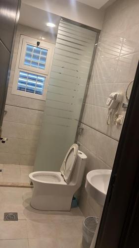 a bathroom with a toilet and a sink at شقق فندقية 2 in Buraydah