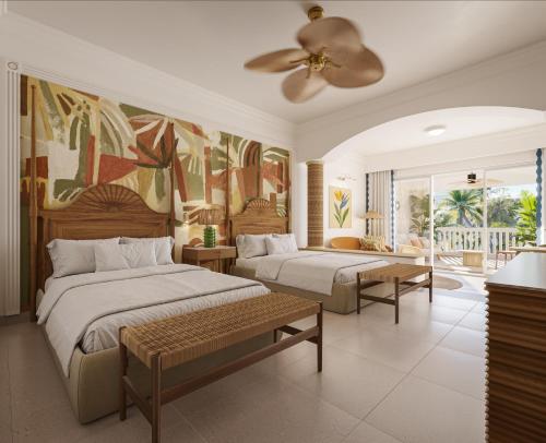 a bedroom with two beds and a ceiling fan at JOIA Rose Hall by Iberostar - Adults Only All Inclusive Resort in Montego Bay