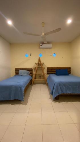 ein Zimmer mit zwei Betten und einer Decke in der Unterkunft Corazón Abierto in Chicxulub