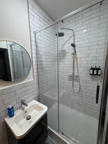 a white bathroom with a sink and a shower at The Recharge Loft in Durham