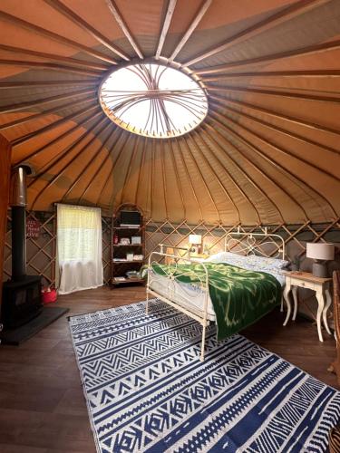a bedroom in a yurt with a bed and a rug at Sunbank Yurt in Llangollen