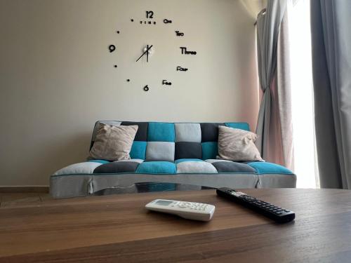 a living room with a blue couch and a clock at Downtown Hub 2 in Alexandroupoli