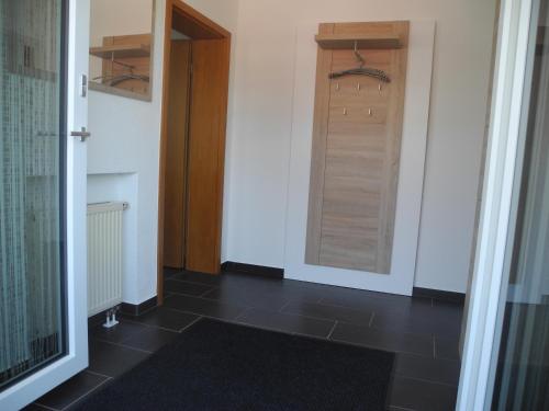 a hallway with a door and a black tile floor at Ferienwohnung Wünsche in Weißensberg