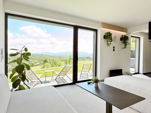 a bedroom with a bed and a large window with a view at The East House ONE in Łapanów