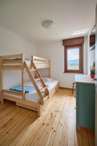 a bedroom with two bunk beds and a kitchen at Meridiana Gemona in Taboga