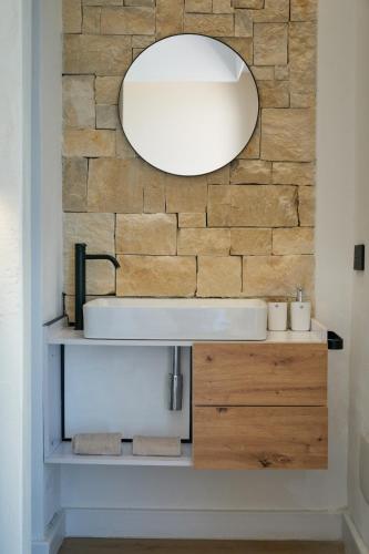 a bathroom with a sink and a mirror on a brick wall at Villa AmOr in Cefalù