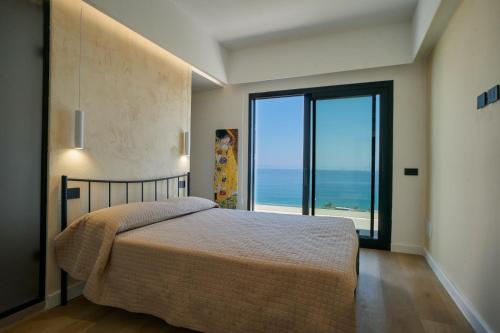 a bedroom with a bed with a view of the ocean at Villa AmOr in Cefalù