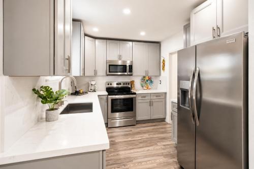 a kitchen with stainless steel appliances and white cabinets at Cozy Private Triple Room in Design District Miami in Miami