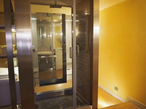 ナポリにあるLa Dimora di Chiaiaの黄色い壁の客室内のガラス張りのシャワー