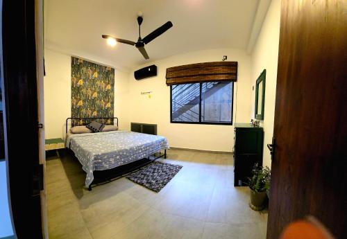 a bedroom with a bed and a ceiling fan at Urban tropics in Colombo