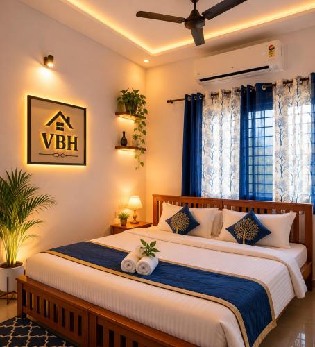 a bedroom with two beds with blue curtains at VBH Tourist Homestay in Guruvāyūr