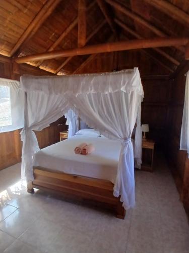 a bedroom with a bed with a white canopy at Finca Paraiso retiros holisticos in San Clemente