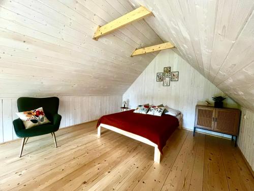 a bedroom with a bed and a chair in a attic at Gawra Pogórze in Jawornik Polski