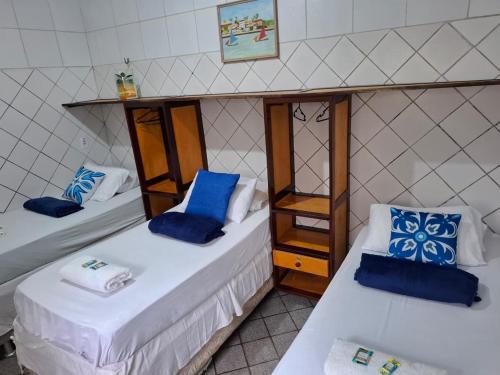 zwei Betten in einem Zimmer mit blauen Kissen darauf in der Unterkunft Hotel Ilha dos Azulejos in São Luís
