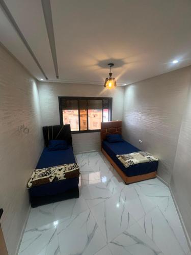 a room with two beds in a room at best standing with ascenceur in El Jadida