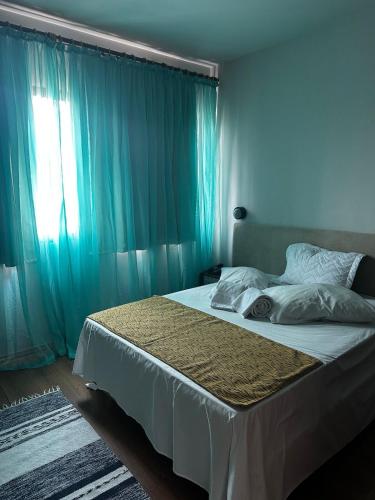 a bedroom with a large bed with blue curtains at Apartamento Saint Moritz flat service in São Bernardo do Campo