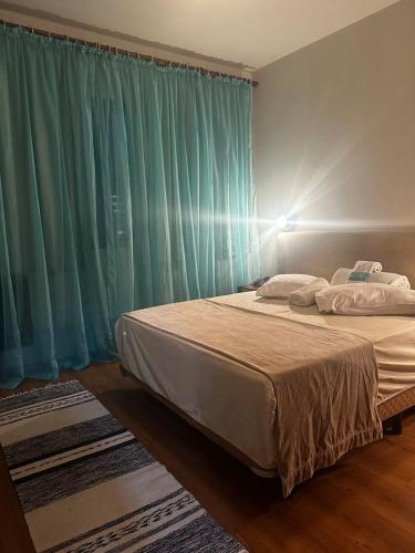 a bedroom with a large bed with blue curtains at Apartamento Saint Moritz flat service in São Bernardo do Campo