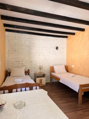 a room with two beds and a brick wall at Vuk Etno domaćinstvo in Barajevo