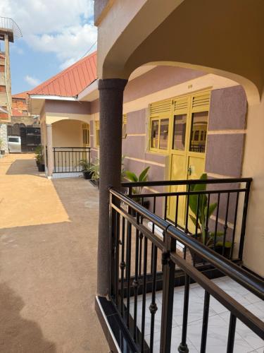 a balcony of a house with a yellow door at Crown Motel Lugala in Kampala