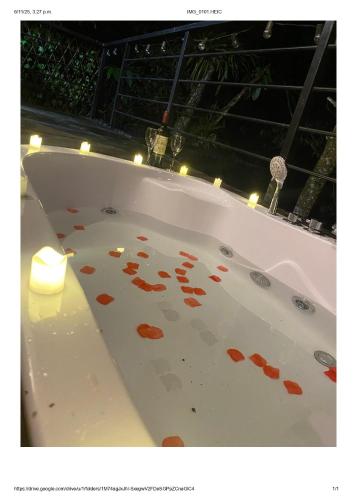 a bath tub with orange petals on the floor at Natural Glamping Cocorna in Cocorná