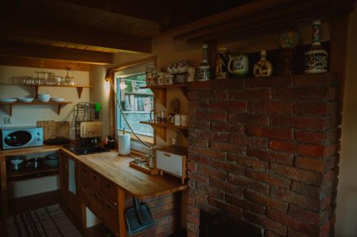 a kitchen with a brick wall and a brick counter at Domek Panorama in Lipowa