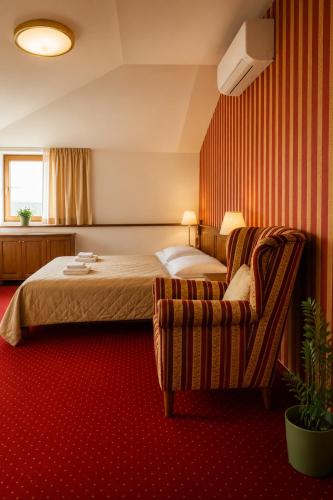 a hotel room with a bed and a chair at Hotel ZÁMOCKÁ KORUNA u Hoffera in Nitra