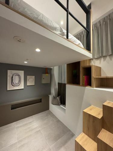 ein Zimmer mit einem Hochbett und einer Treppe in der Unterkunft Dreamloft Hotel in Singapur