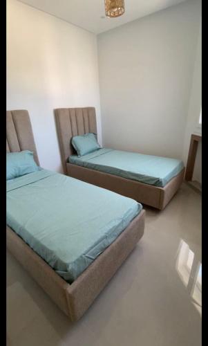 two beds sitting in a room withacers at Appartement S2 résidence costa '0751' 8402'79 fr in El Ahmar
