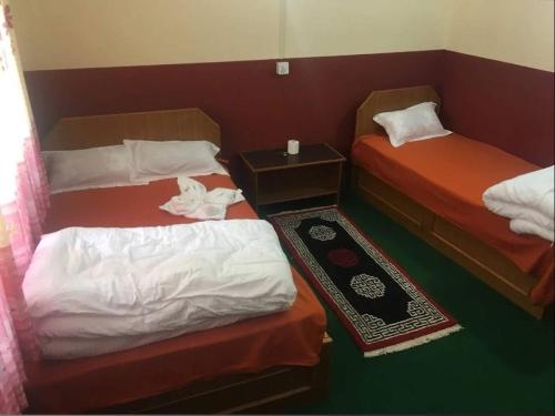 a room with two beds and a table with at Marpha appleland hotel and suite in Tukucha