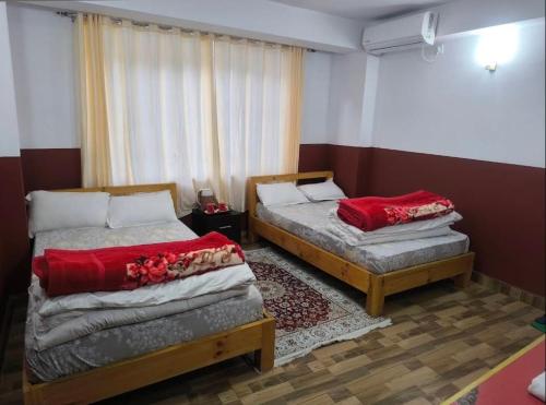 a bedroom with two beds and a window at Marpha appleland hotel and suite in Tukucha